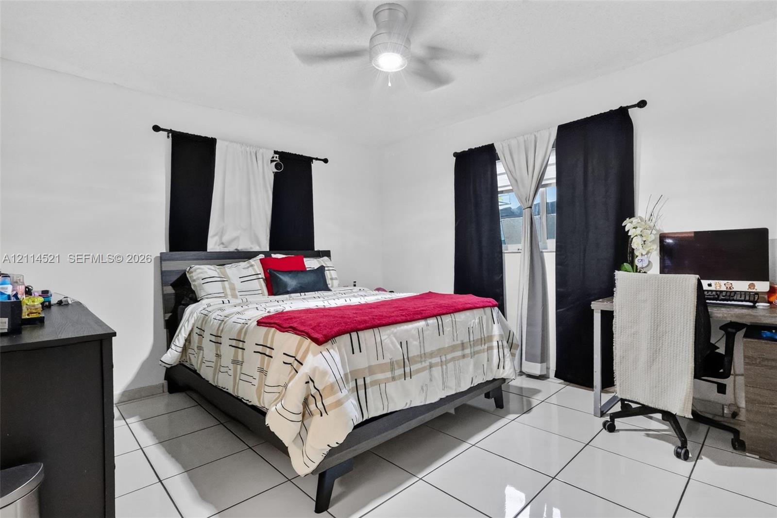 Neutral-toned interior space featuring polished tile flooring and a central ceiling fan with integrated lighting