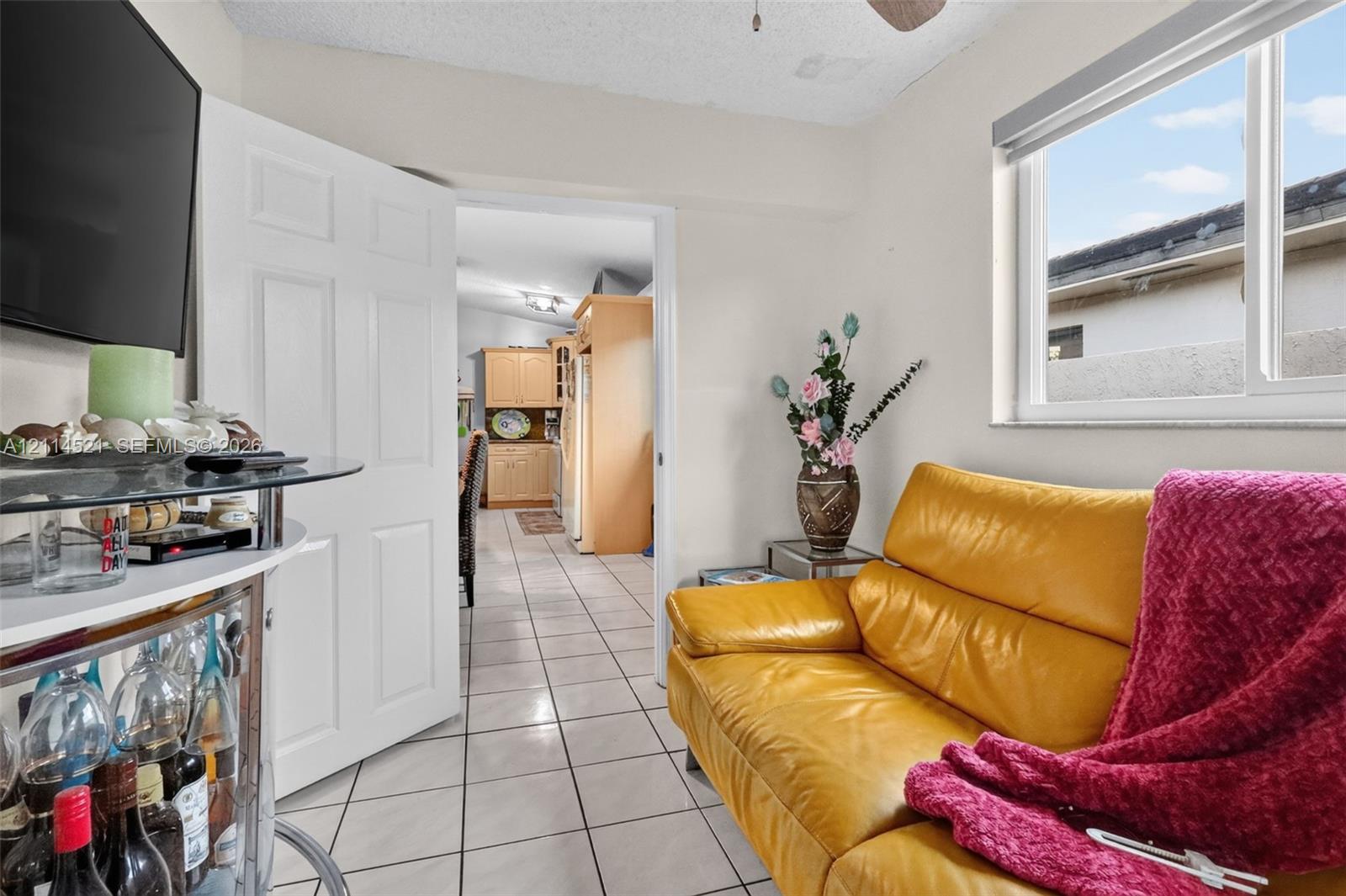Ceramic tile flooring, white six-panel interior door, and horizontal sliding window with neutral trim