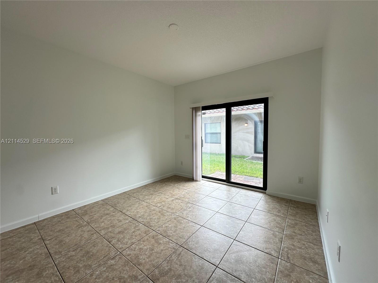 Interior space featuring neutral wall tones, large-format tile flooring, and sliding glass doors