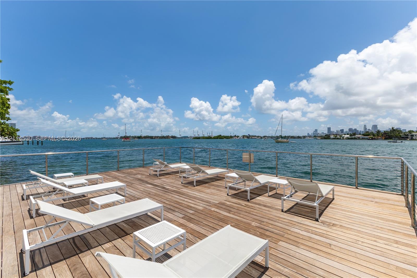 Waterfront wooden deck featuring stainless steel railings and open water exposure