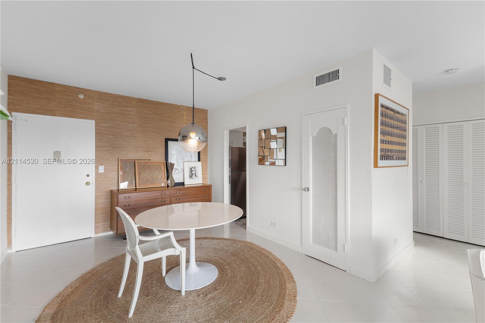 Textured wood-finish accent wall, spherical glass pendant lighting, interior door with a frosted glass insert, and louvered closet doors