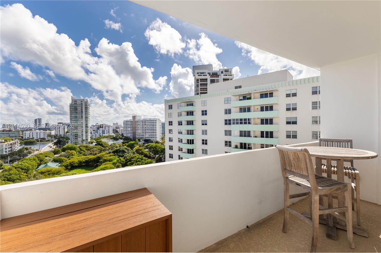 Private covered balcony with a solid waist-high wall and wood-finish cabinetry