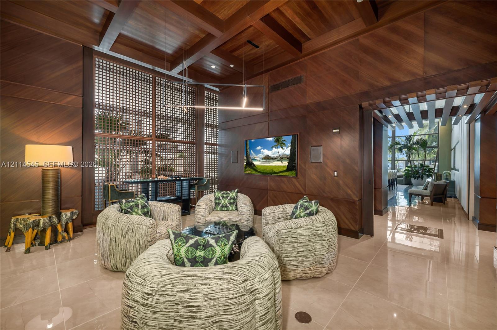 Custom wood-paneled walls and ceiling featuring exposed beams, stone-finish flooring, floor-to-ceiling latticed window detailing, and recessed lighting