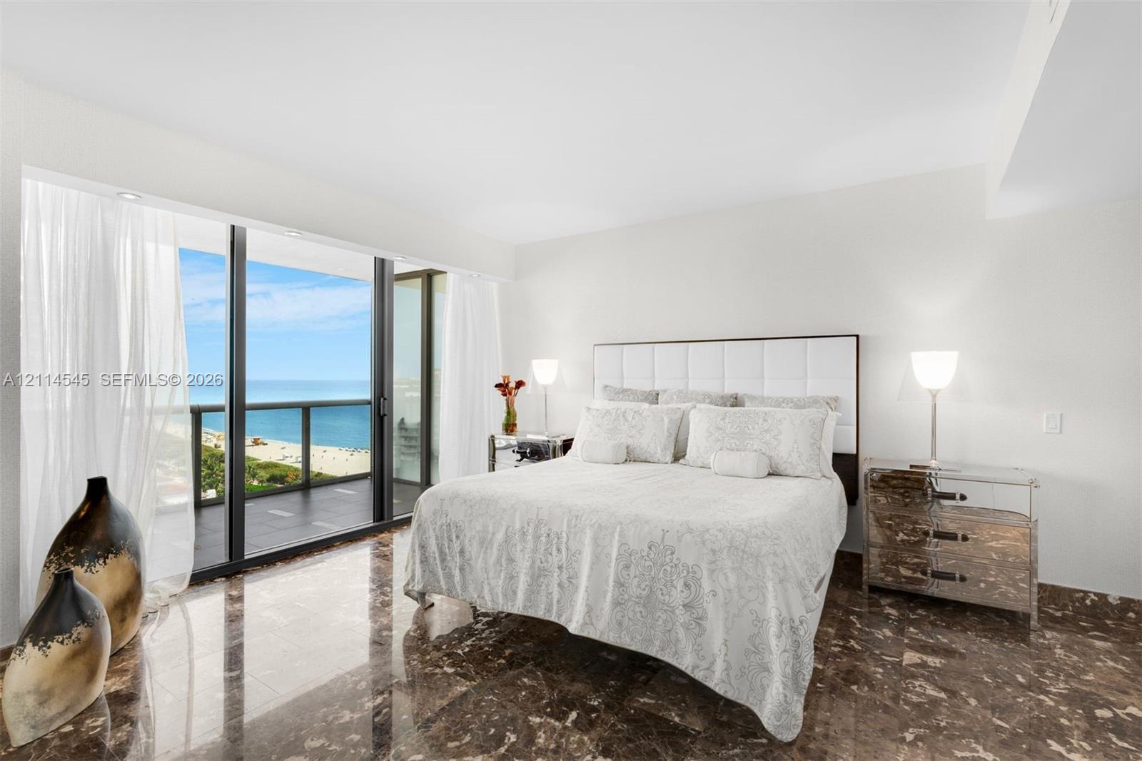 Floor-to-ceiling sliding glass doors, private balcony, polished stone flooring, and recessed ceiling lighting