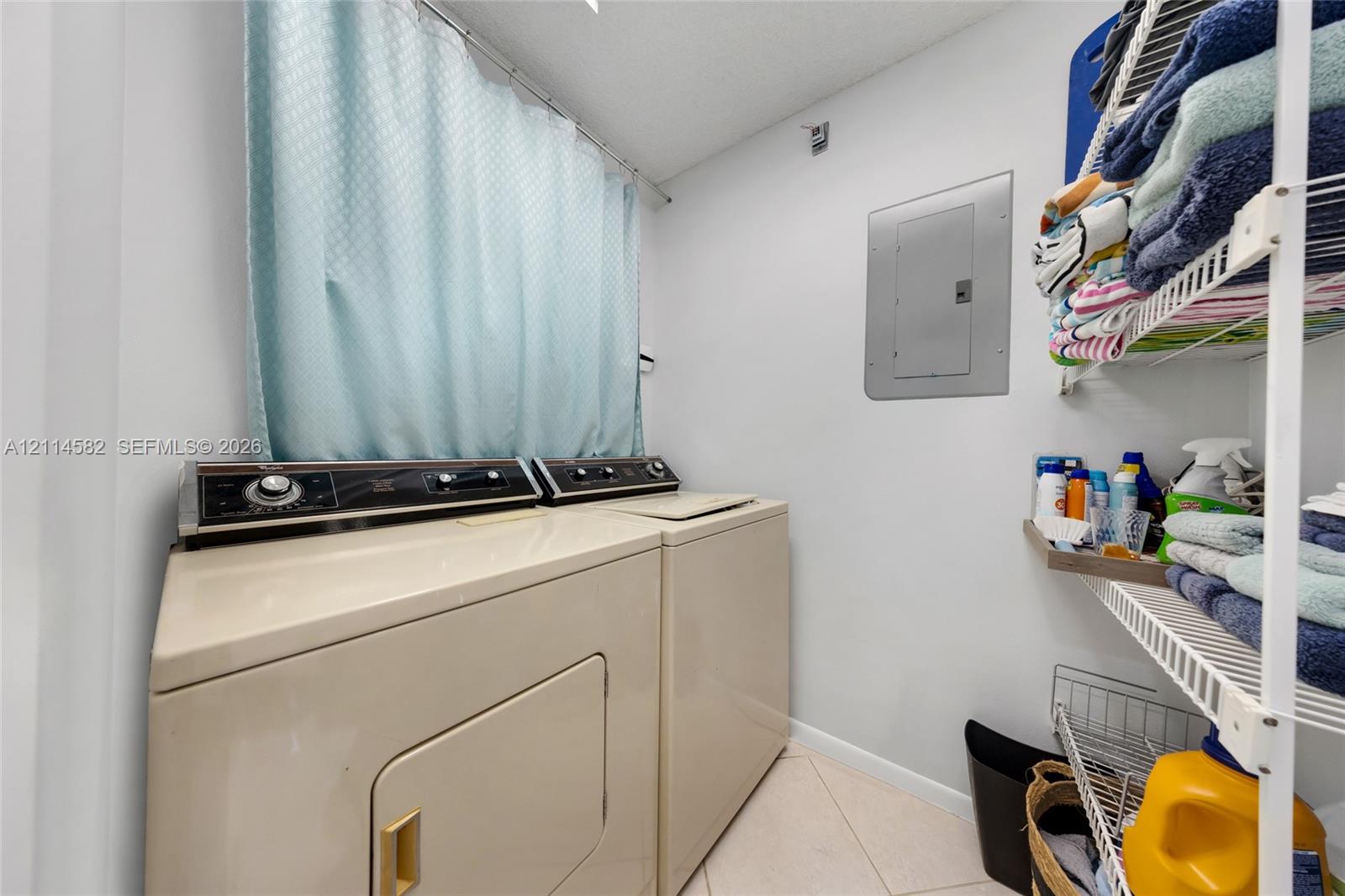 Utility space featuring tile flooring and built-in wire shelving