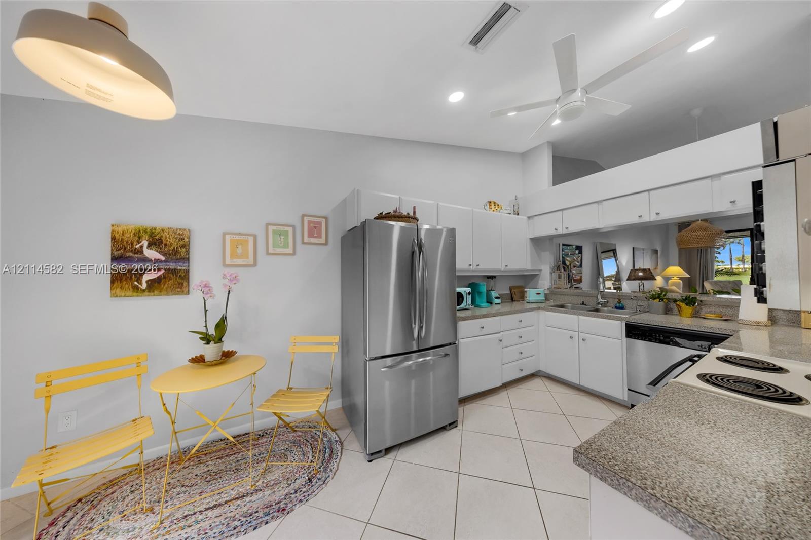 Kitchen featuring white cabinetry, stone-finish countertops, stainless steel French-door refrigerator, recessed ceiling lighting, and ceramic tile flooring