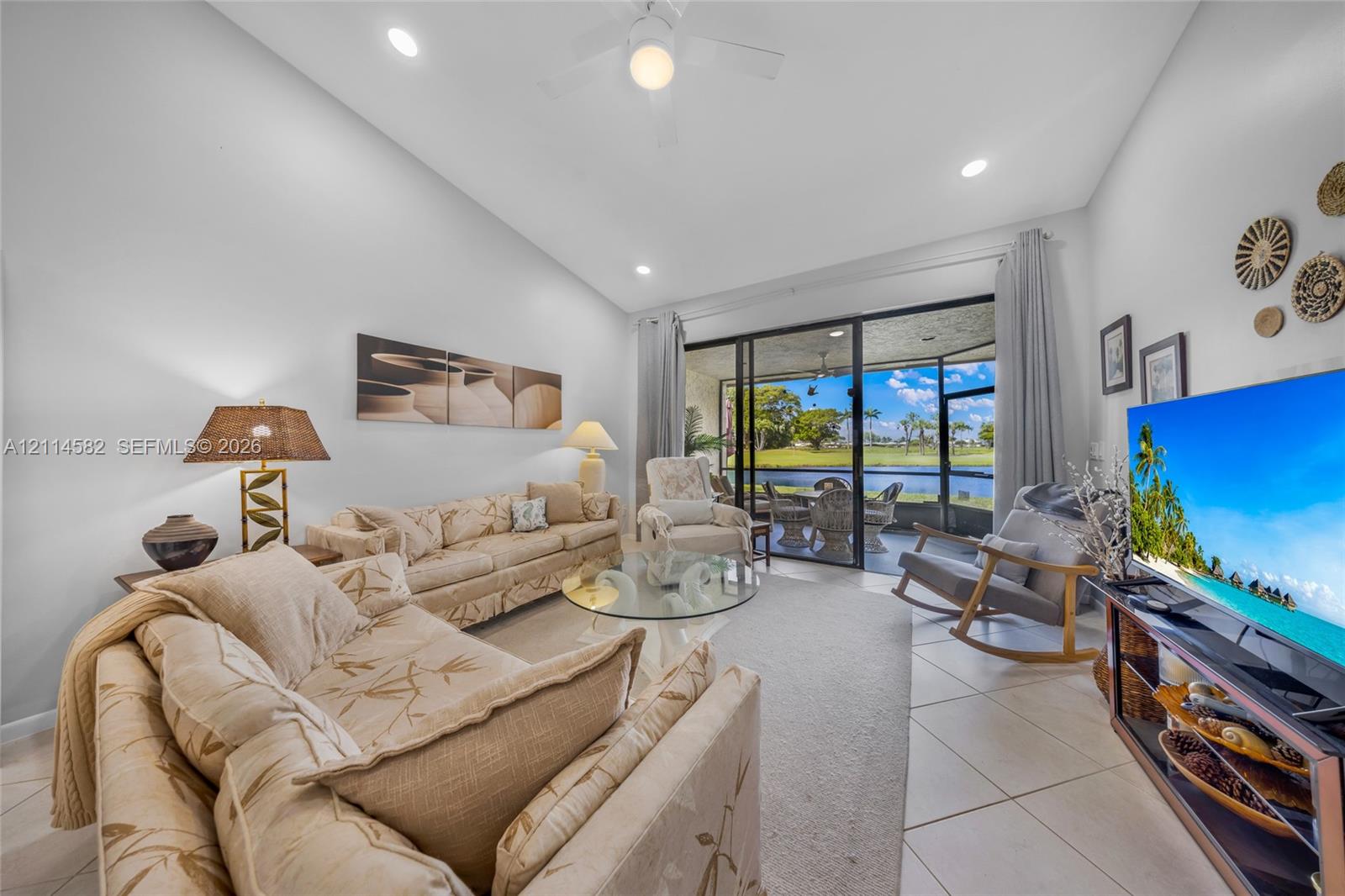 Living area featuring vaulted ceilings, oversized tile flooring, recessed lighting, a ceiling fan, and large sliding glass doors providing outdoor access