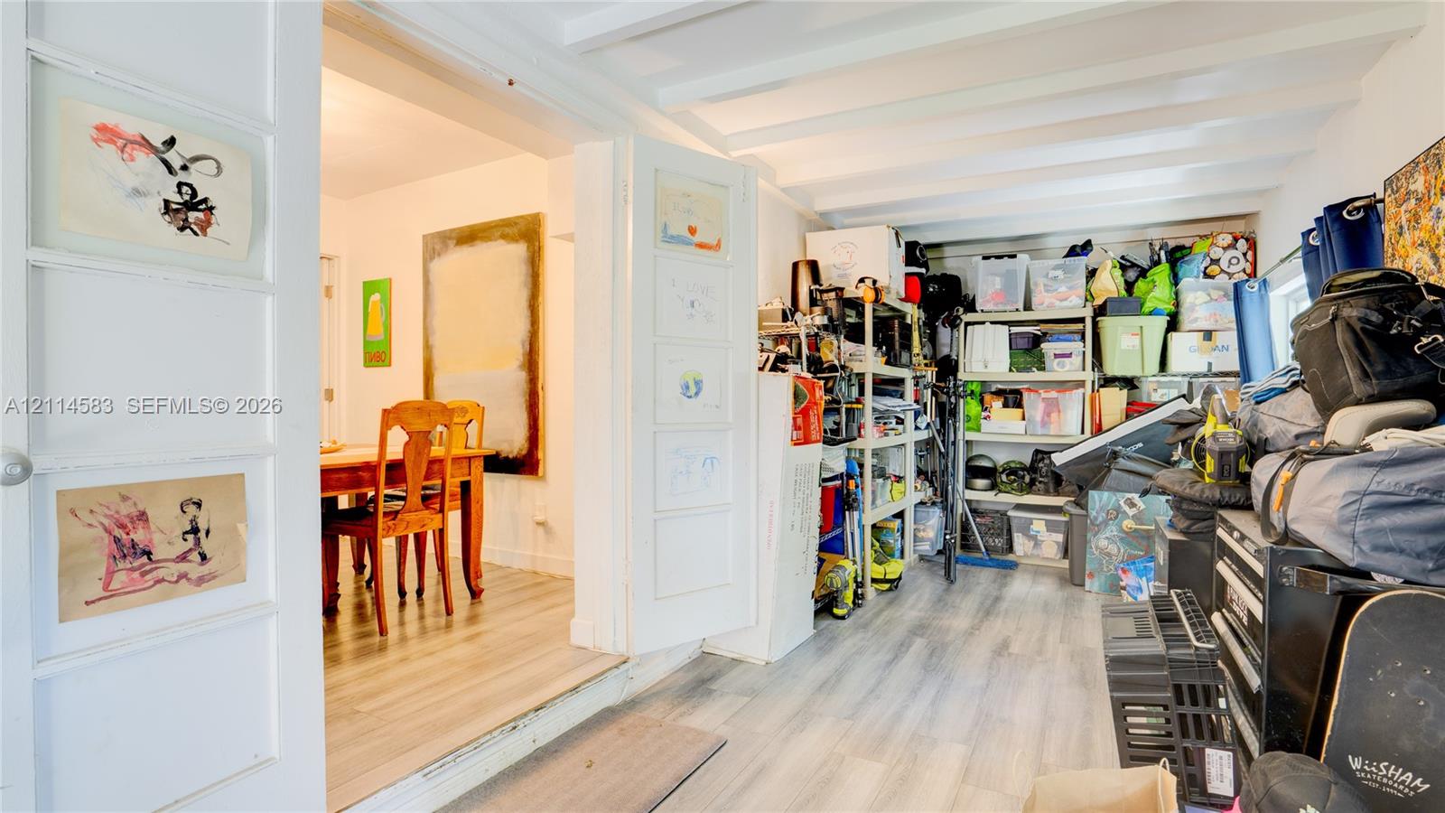 Wood-finish flooring, exposed ceiling beams, and multi-panel swinging interior doors