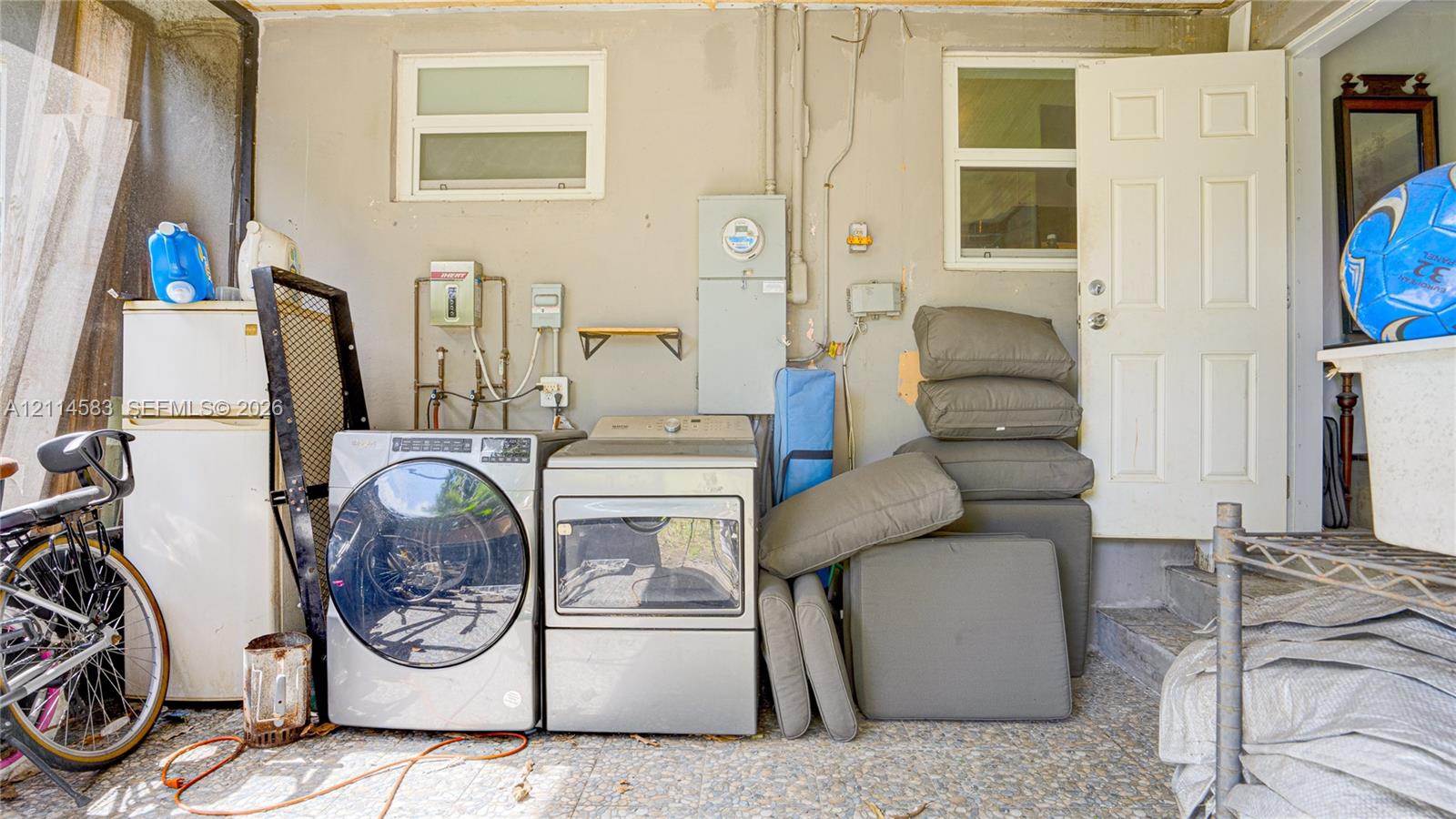 Laundry area featuring dedicated water hookups, dual windows, and an exterior door