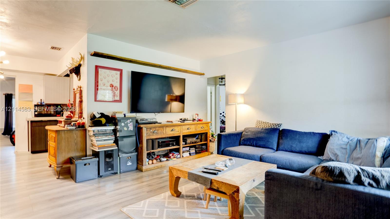 Light-toned wood-finish flooring and a prominent horizontal wooden wall accent beam Light-toned wood-finish flooring and a prominent horizontal wooden wall accent beam