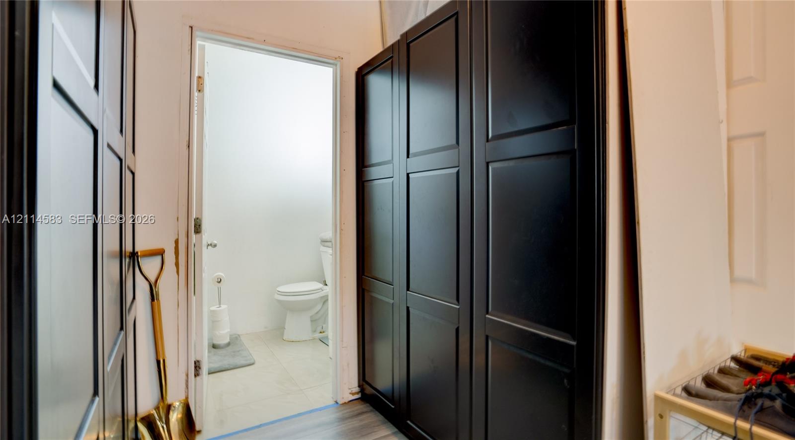Custom built-in black cabinetry with recessed panel doors and wood-finish flooring