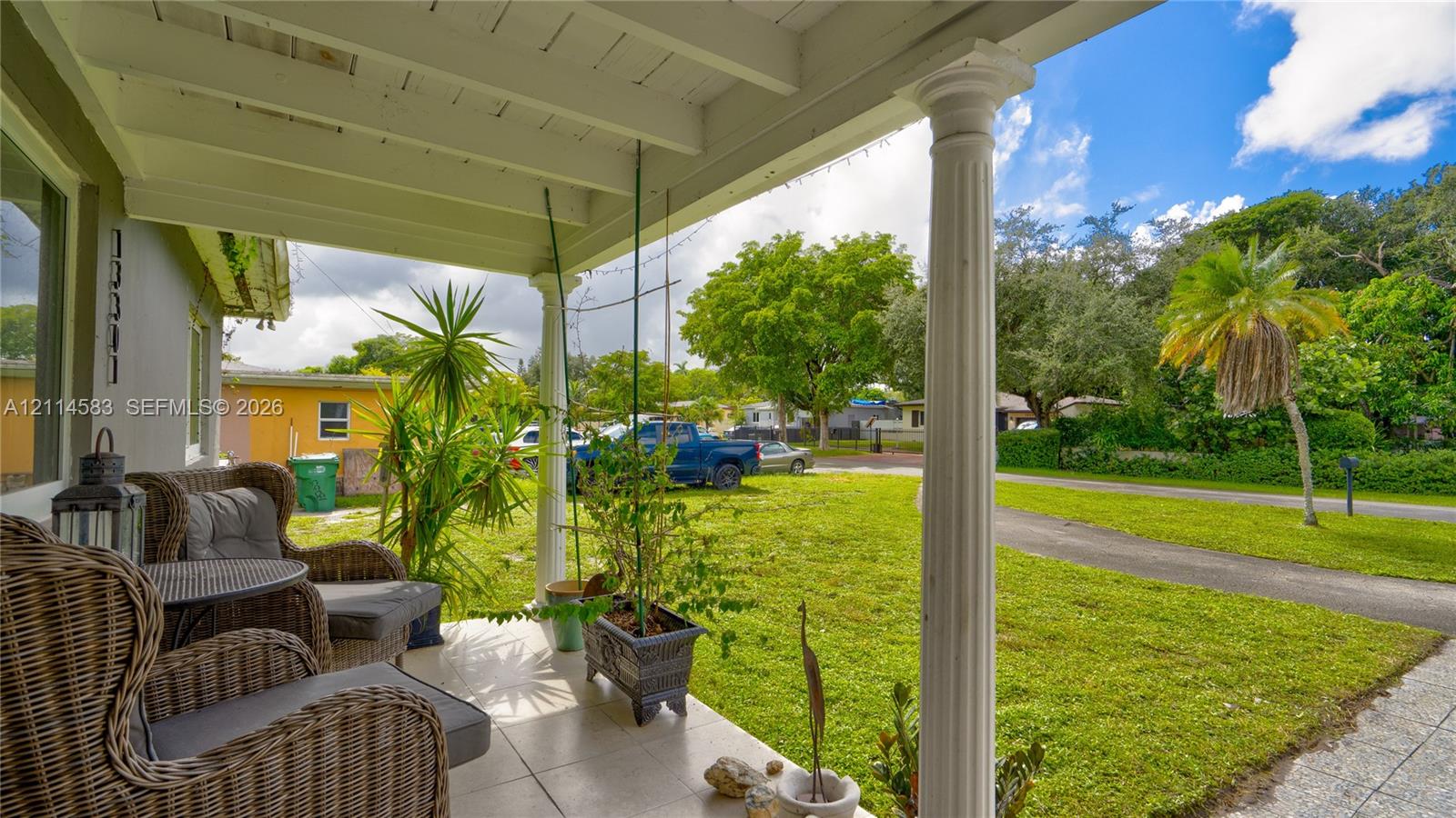 Covered front porch featuring tile flooring, structural columns, and exposed rafter ceiling design Covered front porch featuring tile flooring, structural columns, and exposed rafter ceiling design
