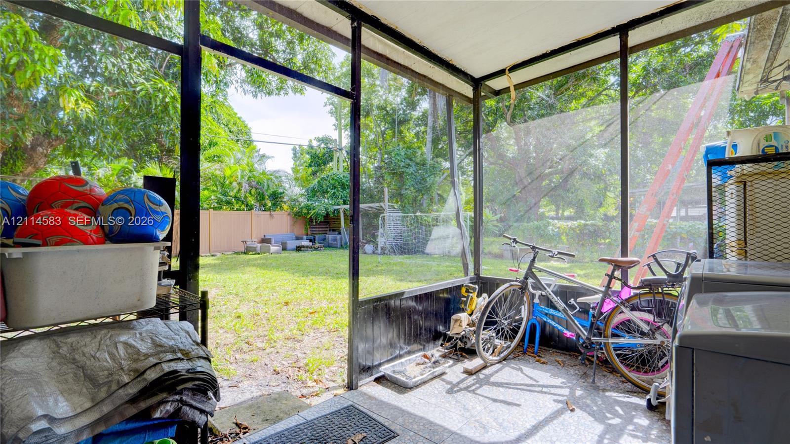 Screened-in porch featuring concrete flooring and a fenced backyard