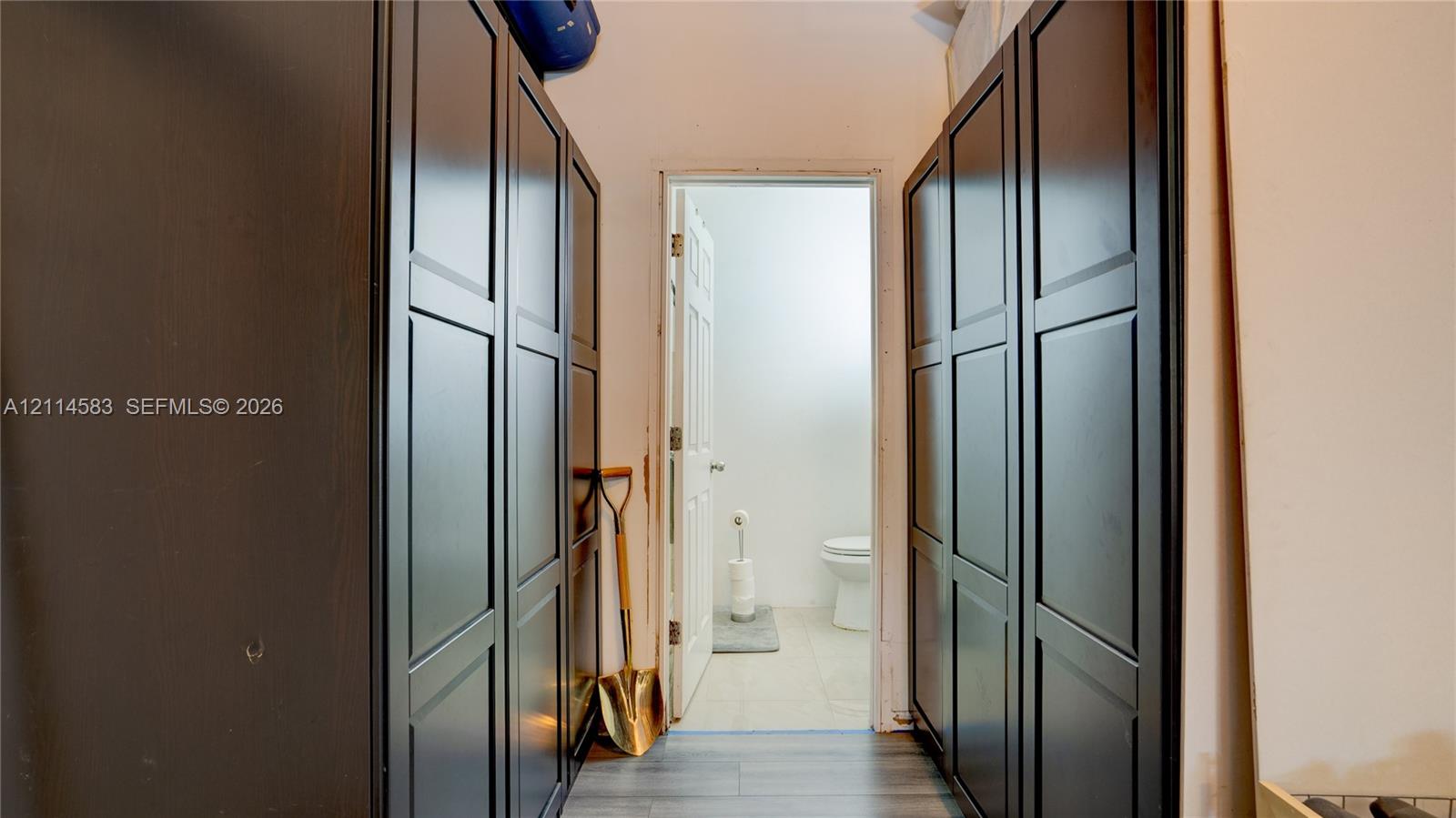Full-height, dark-finish cabinetry with recessed panels and wood-finish flooring