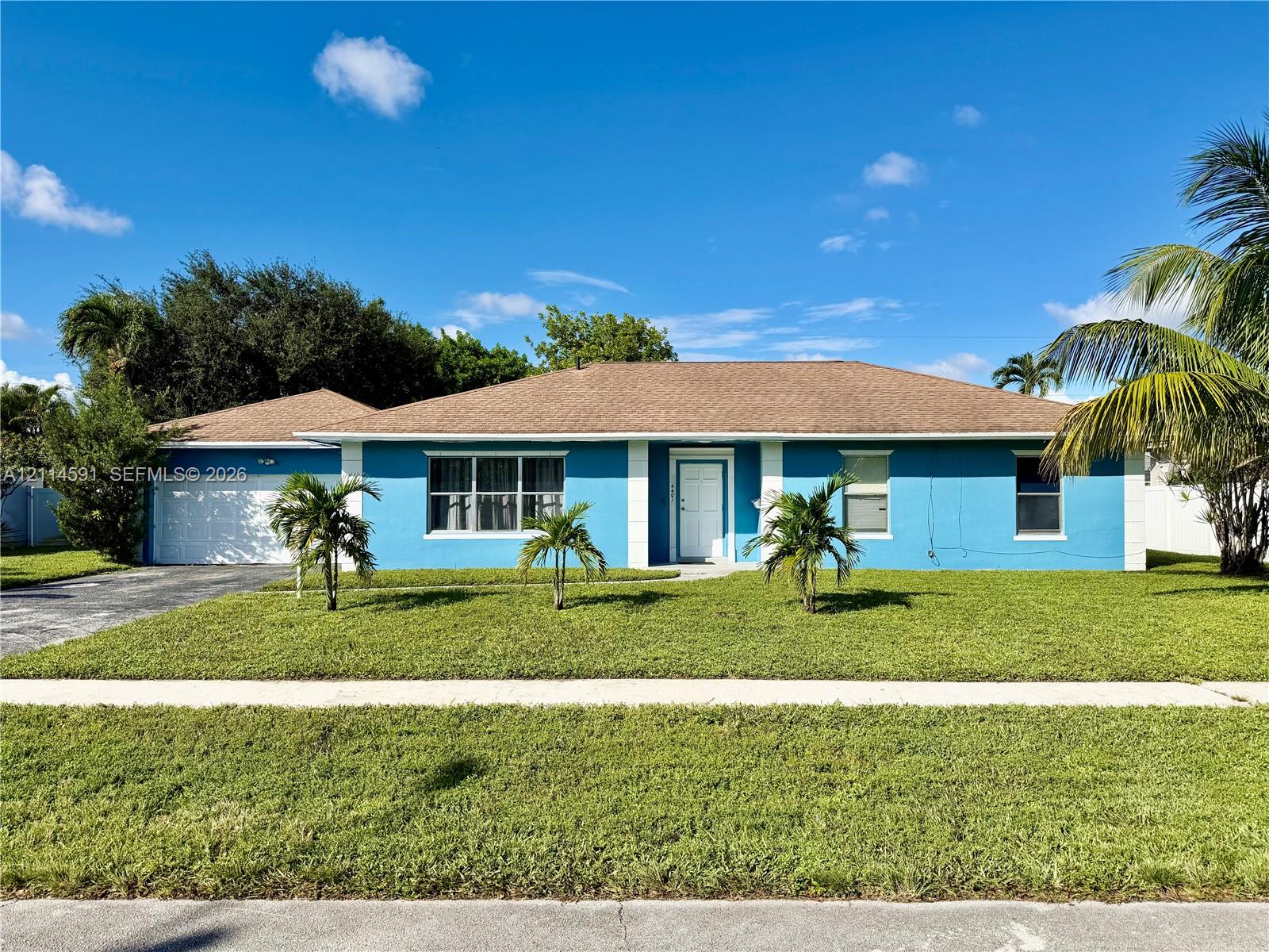Single-story residence featuring a hipped roof, attached garage, multi-pane windows, and a manicured lawn
