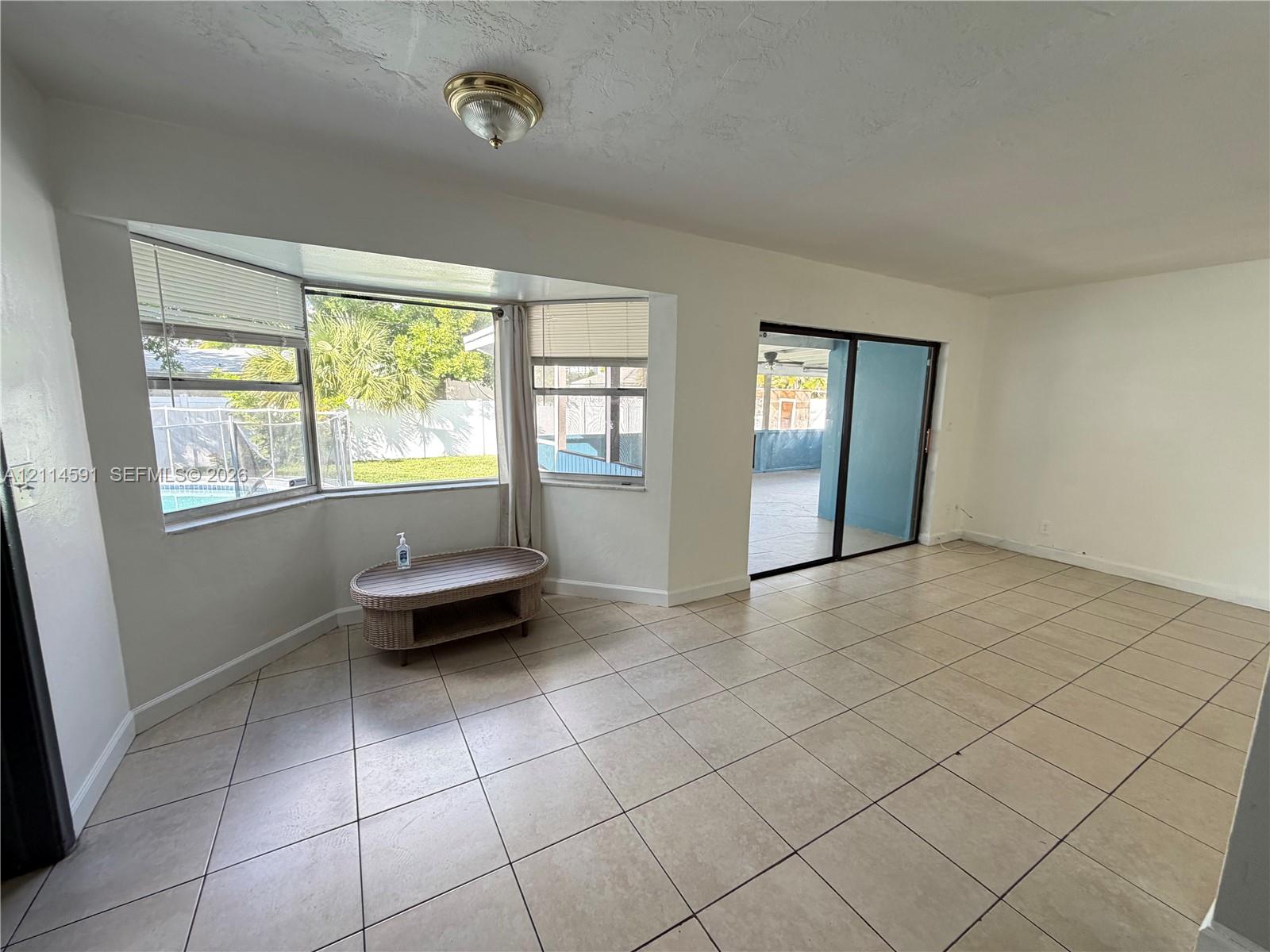 Ceramic tile flooring, bay window, and sliding glass doors featuring metal frames