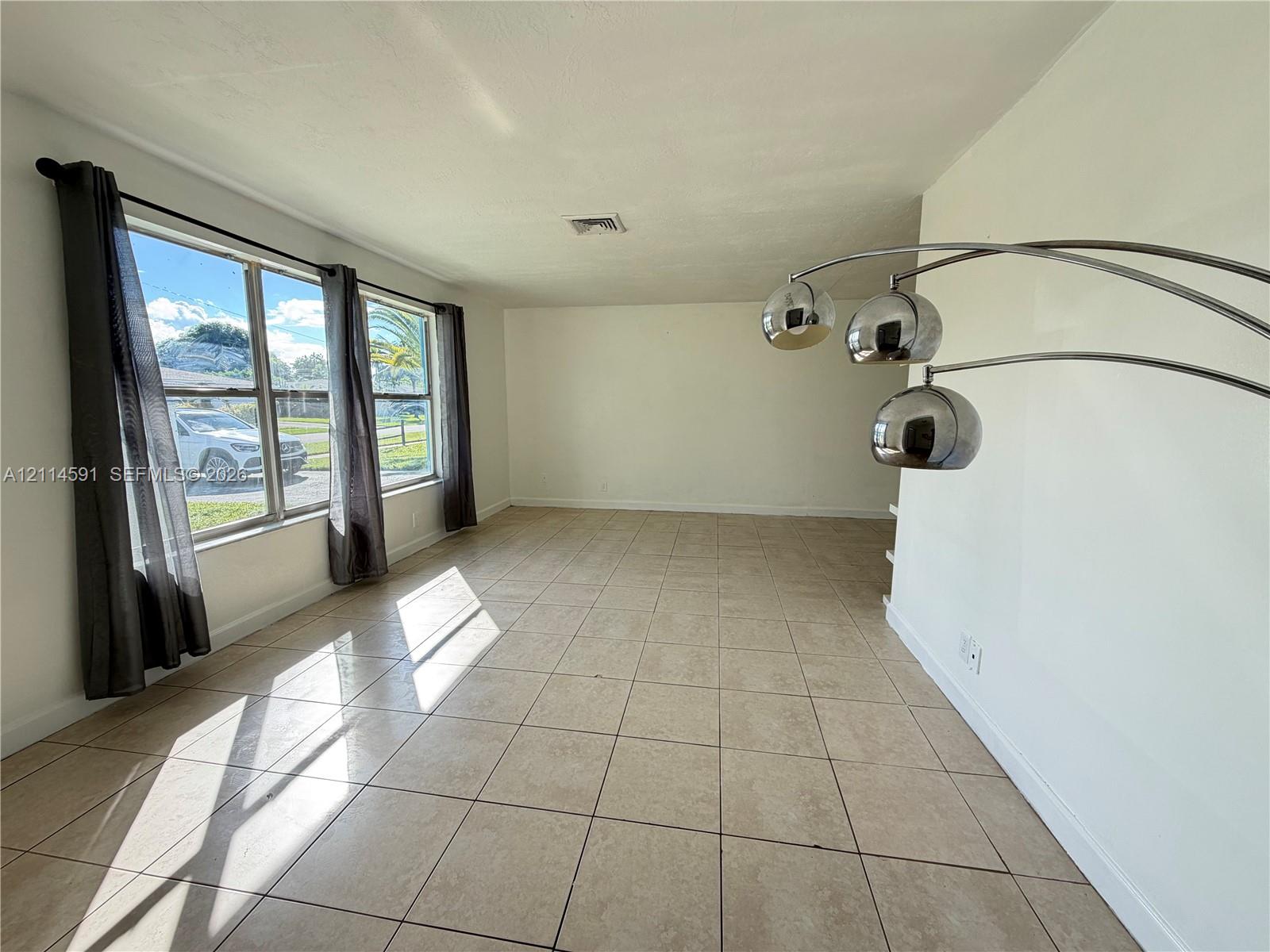 Neutral-toned tile flooring, large multi-pane windows, and minimalist smooth-finish walls