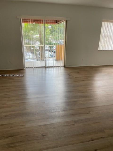 Wood-finish flooring, sliding glass patio door, and vertical window blinds