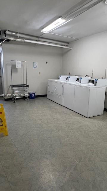 Dedicated laundry room featuring vinyl tile flooring and overhead fluorescent lighting