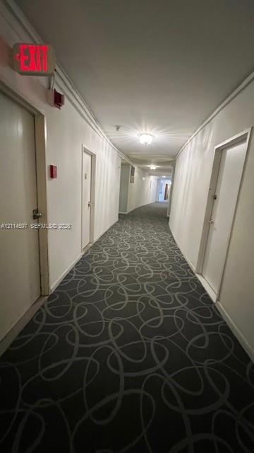 Interior hallway featuring patterned carpeting, recessed ceiling lighting, and solid-core doors Interior hallway featuring patterned carpeting, recessed ceiling lighting, and solid-core doors