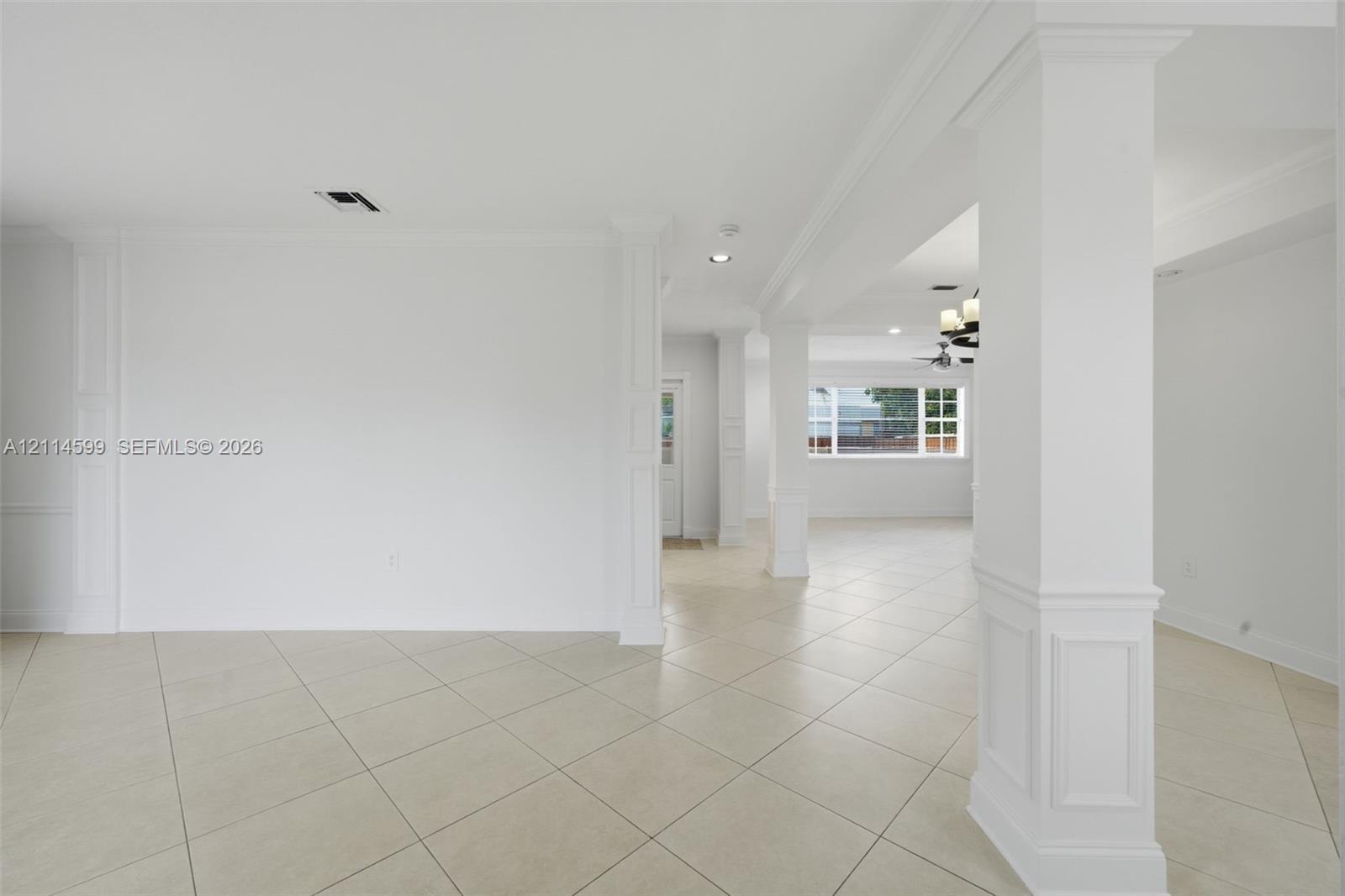 Interior space featuring large-format diagonal tile flooring, custom millwork on structural columns, recessed lighting, and multi-pane windows