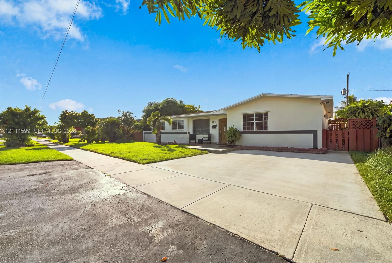 Single-story residence featuring a smooth stucco exterior, multi-pane windows, a concrete driveway, and gated side yard access Single-story residence featuring a smooth stucco exterior, multi-pane windows, a concrete driveway, and gated side yard access