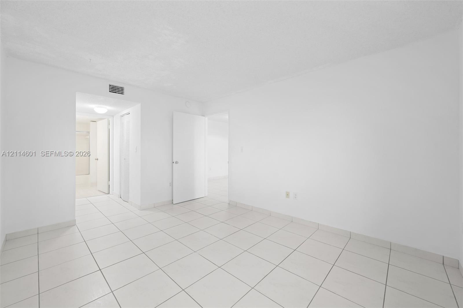 Interior space featuring large-format ceramic tile flooring, solid-core interior doors, and neutral wall finishes
