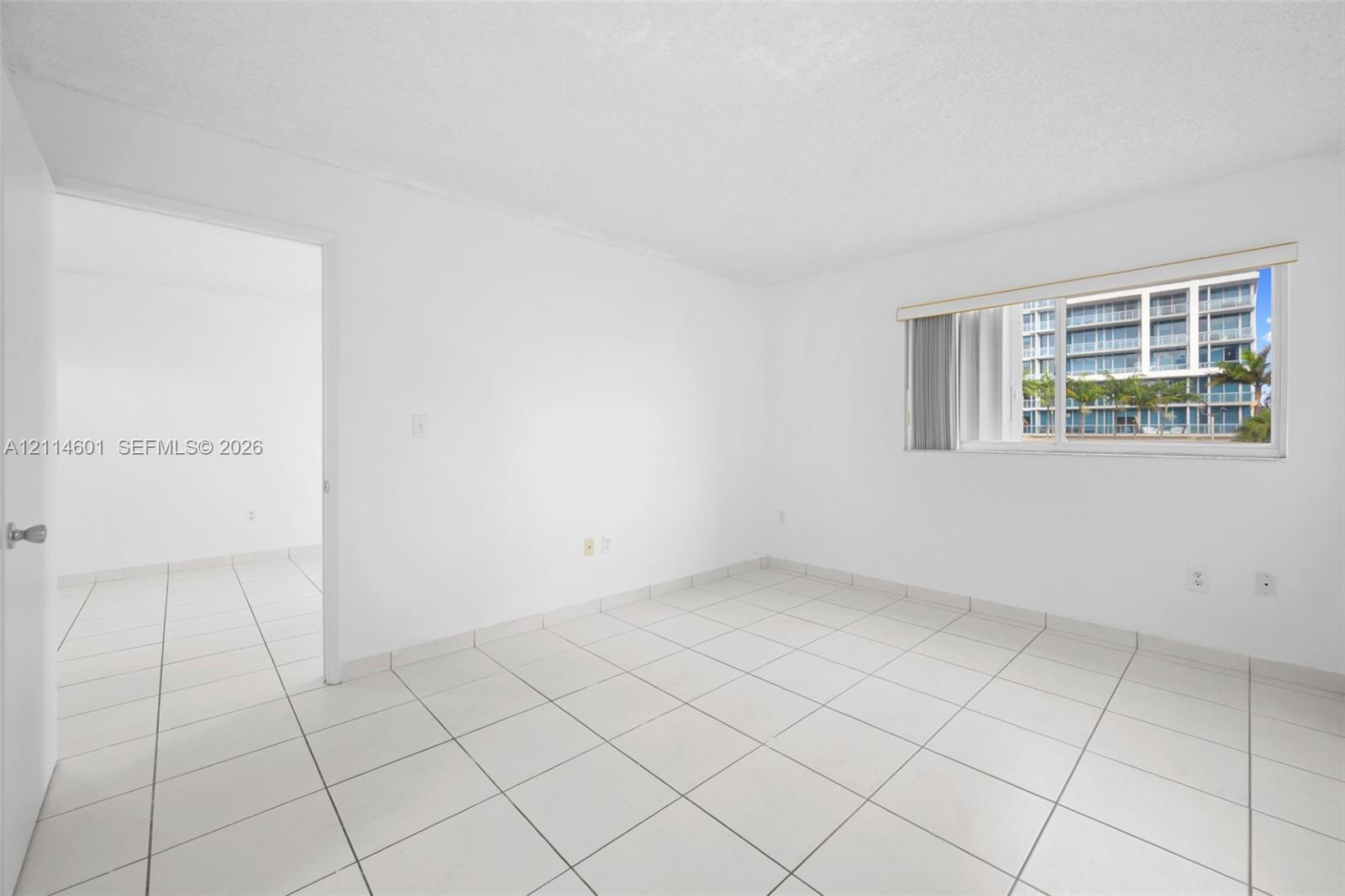 Interior room featuring neutral wall finishes, tile flooring, and a sliding glass window