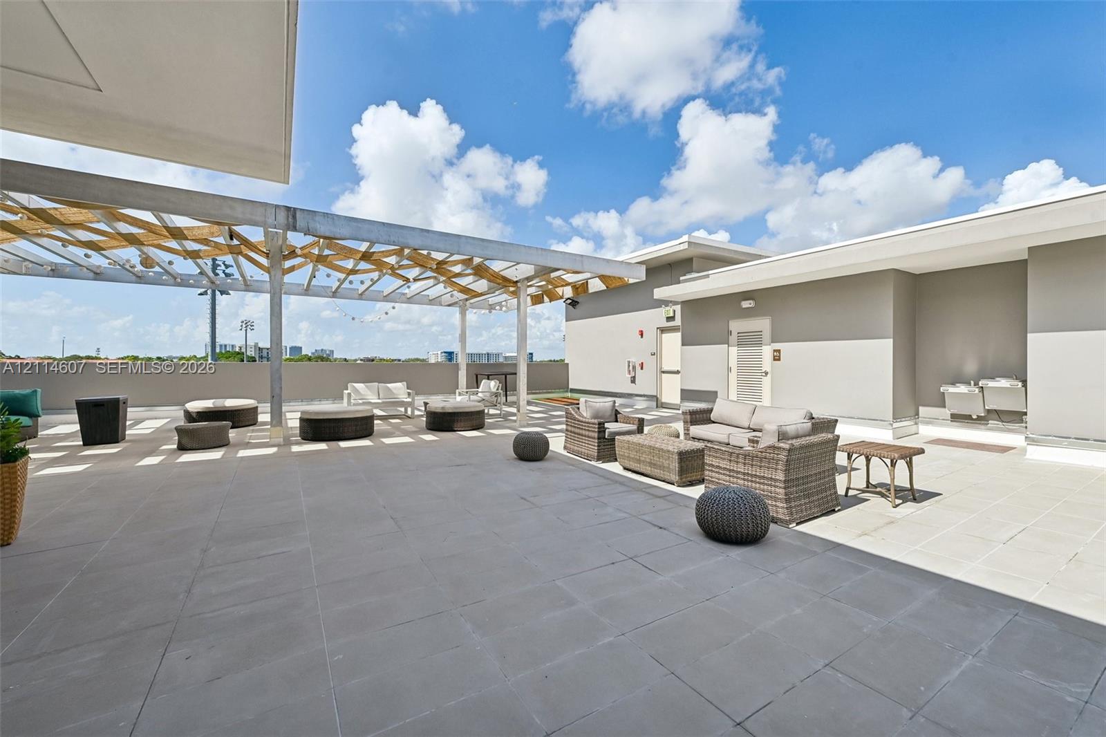 Expansive rooftop terrace featuring large-format tile flooring and a structural wooden pergola
