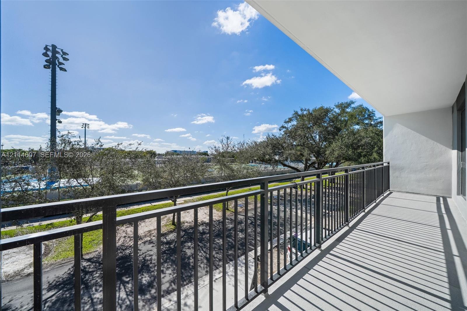 Covered balcony with black metal railings and concrete flooring