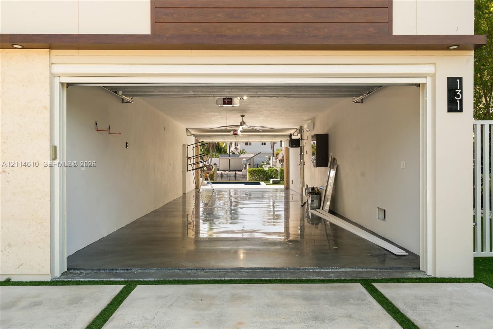 Multi-bay tandem garage featuring a polished concrete floor, recessed lighting, and direct-access exterior entryway