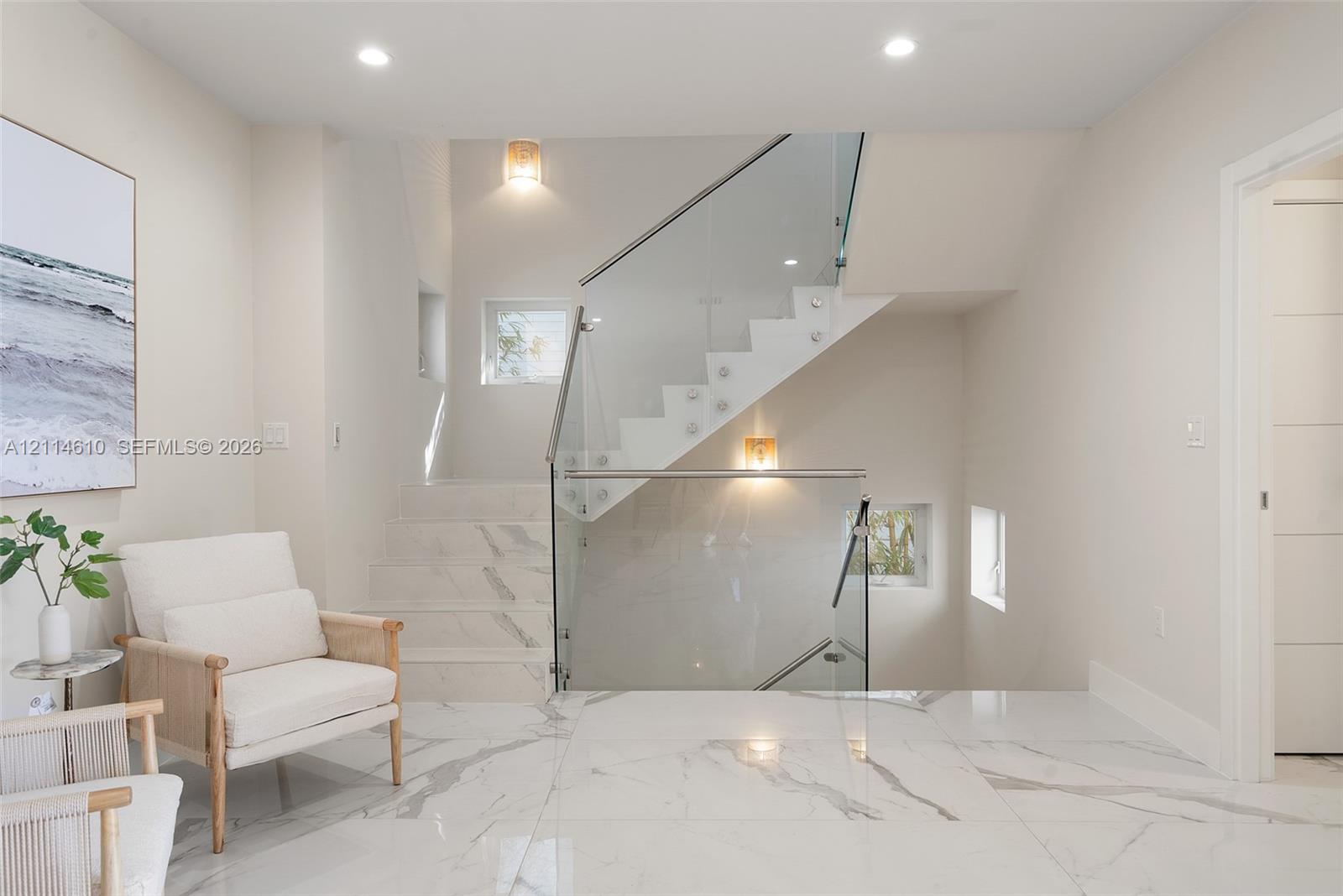 Staircase featuring a frameless glass railing, stone-finish flooring, and recessed ceiling lighting