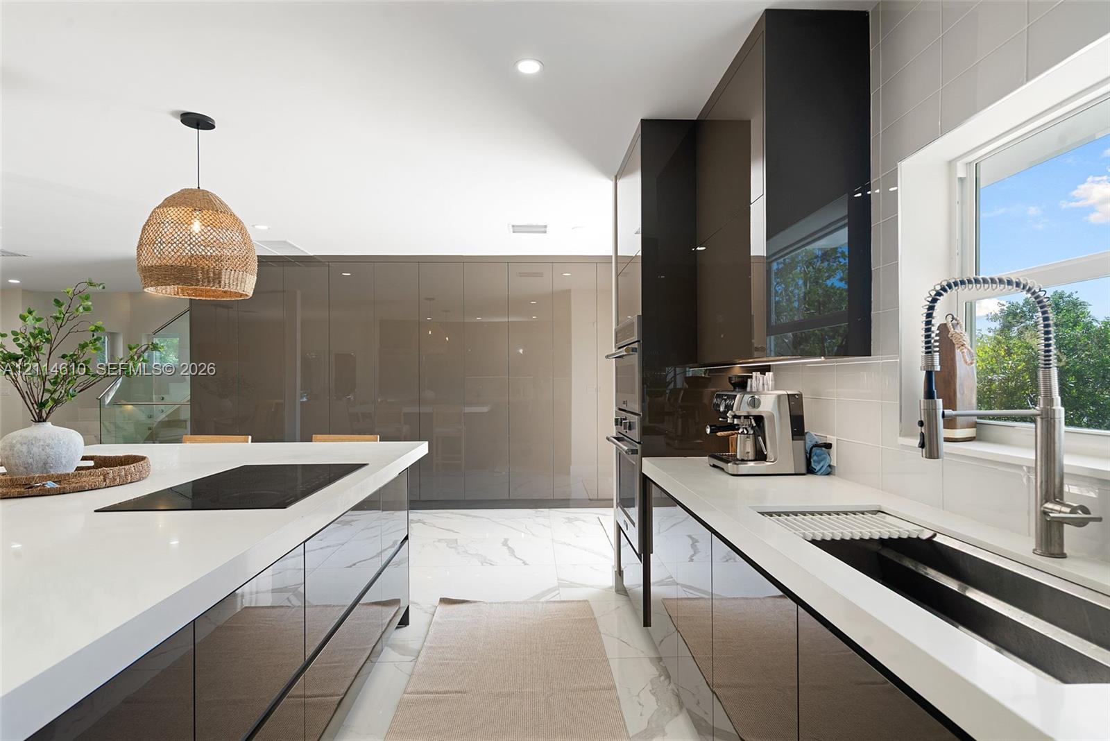 Kitchen featuring high-gloss cabinetry, stone-finish countertops, tile flooring with stone-vein detailing, stainless steel wall-mounted oven, and a gooseneck faucet