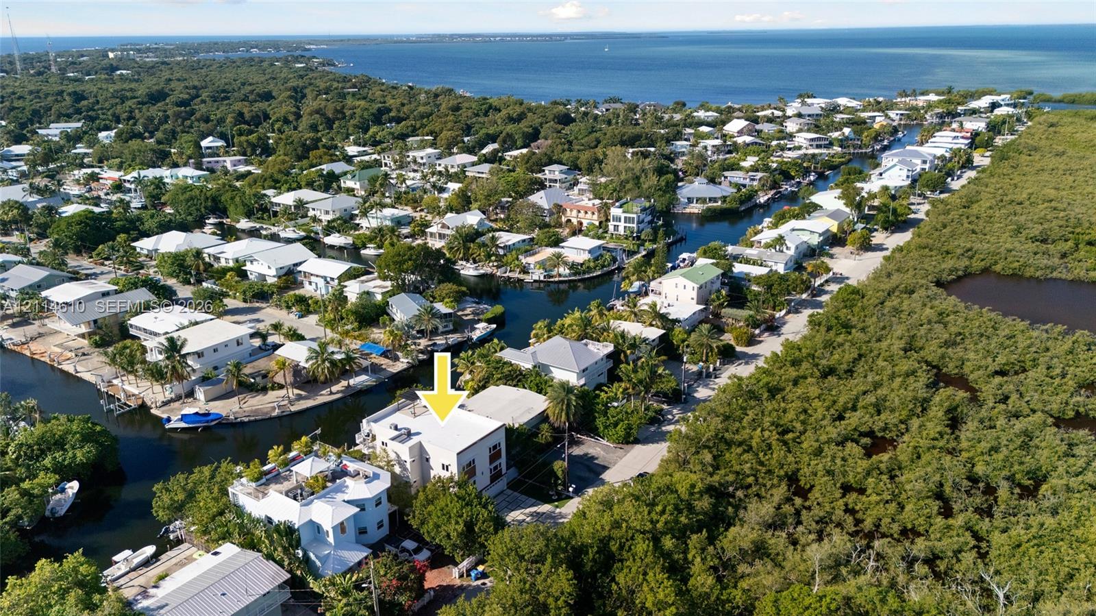 Aerial perspective of a multi-story property featuring a flat roof and proximity to a waterway canal system