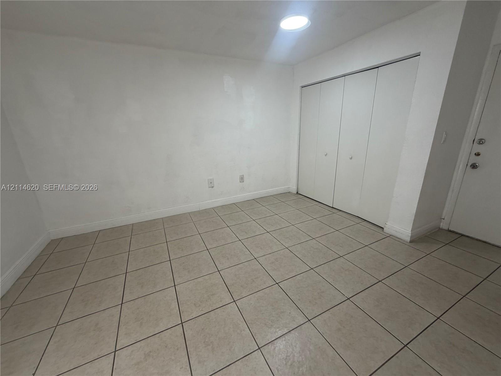 Room featuring ceramic tile flooring, a multi-panel closet with dual doors, and a ceiling-mounted recessed light