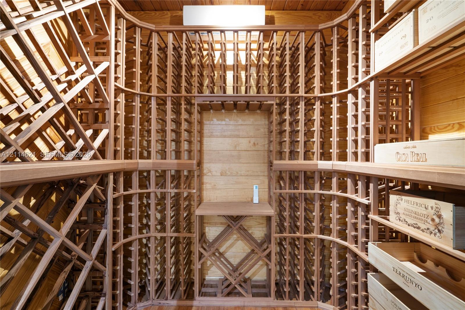 Custom built-in wood wine racking with individual bottle storage, diamond-patterned bins, and a central display shelf Custom built-in wood wine racking with individual bottle storage, diamond-patterned bins, and a central display shelf