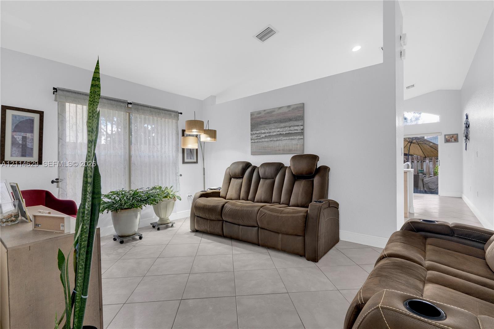 Vaulted ceilings, large-format tile flooring, recessed lighting, and expansive windows