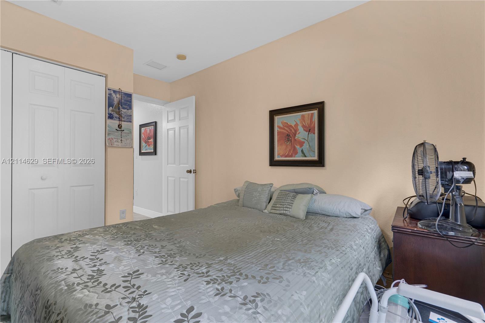 Room featuring a reach-in closet with dual-panel sliding doors and a white four-panel interior door