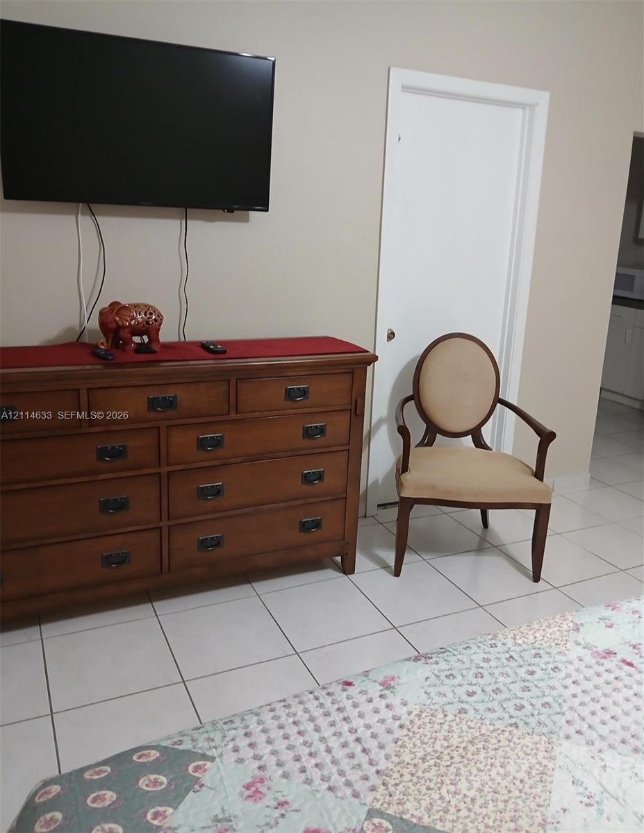 Light-colored ceramic floor tile and a solid-core interior door