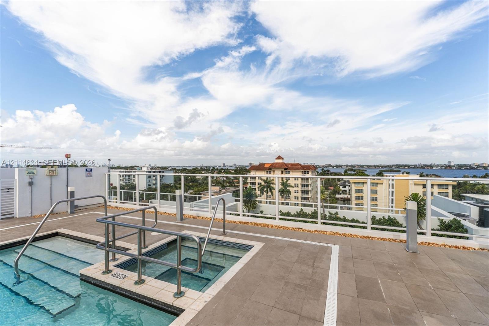 Rooftop terrace featuring a tiled deck, integrated pool with metal safety rails, and a glass perimeter railing