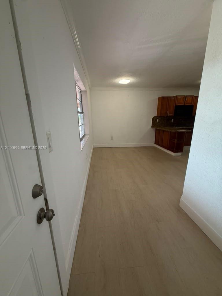 Interior featuring wood-finish flooring, white walls, and a multi-pane window