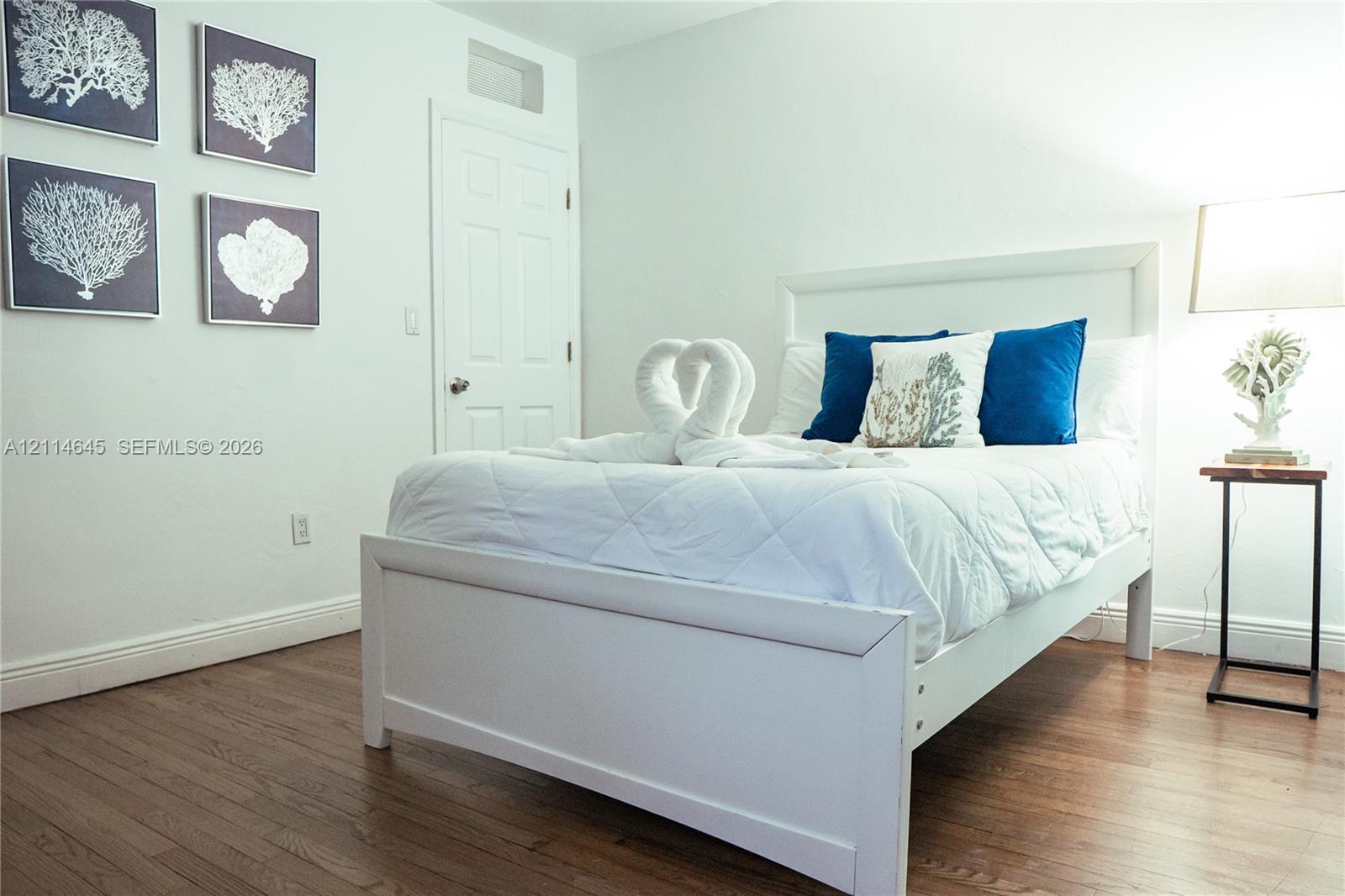 Wood-finish flooring and a white paneled door