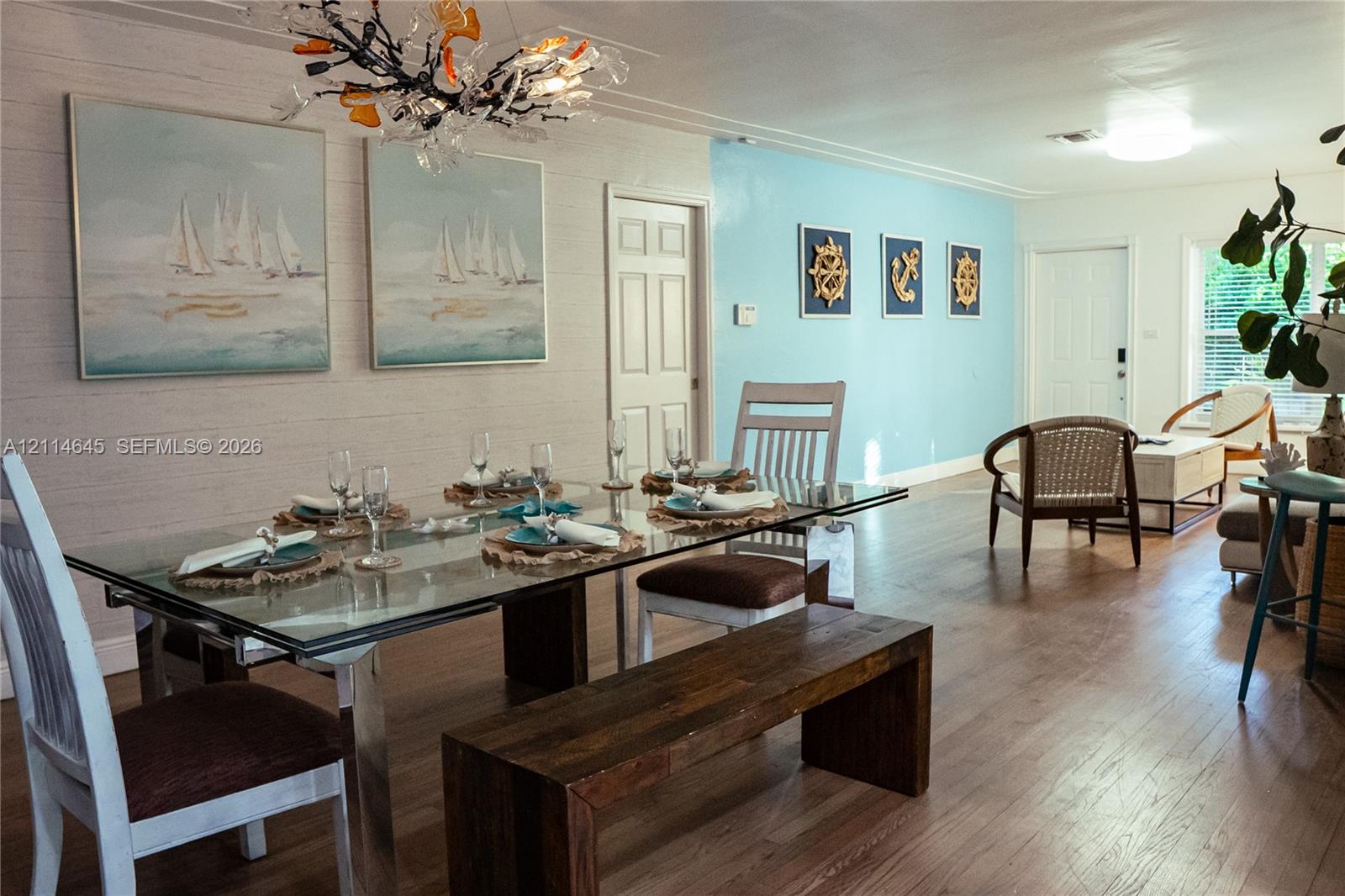 Wood-finish flooring, textured wall treatments, and statement chandelier lighting