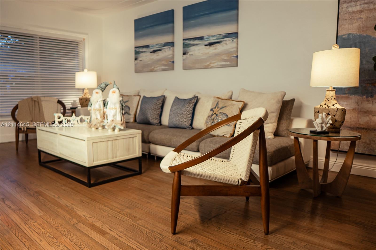 Living area featuring wood-finish flooring and horizontal blind window treatments