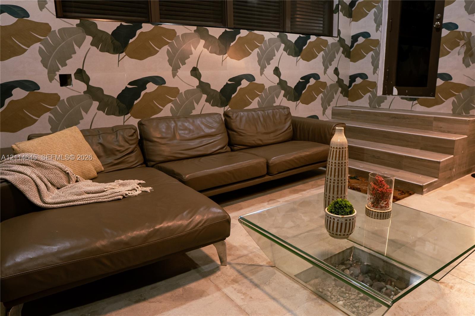 Large-format patterned wall coverings, stone-finish tile flooring, and integrated stone-surfaced stairs
