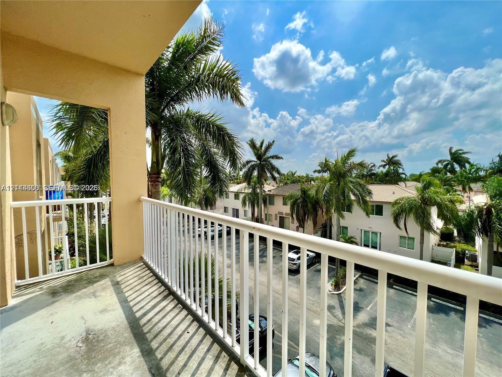 Covered balcony featuring concrete flooring and a white metal railing