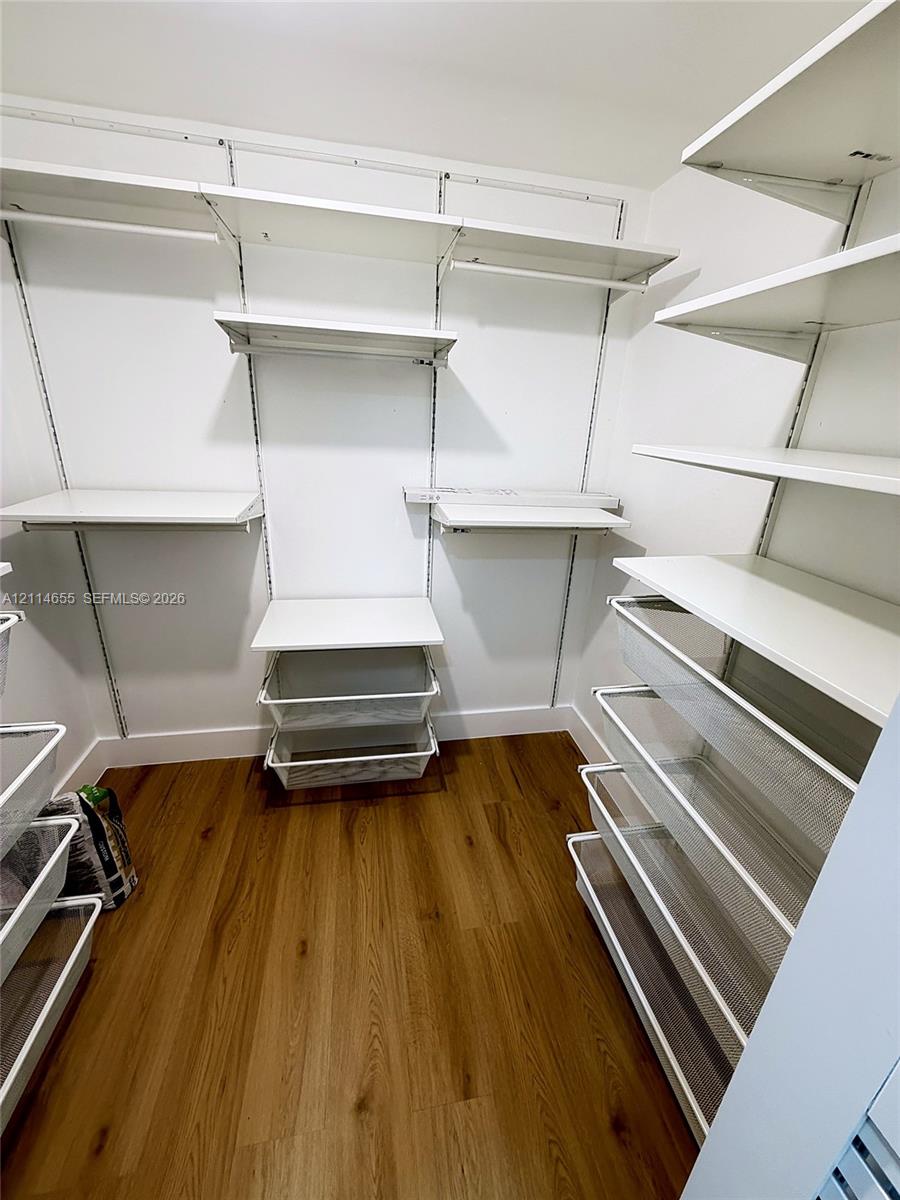 Light-toned wood-finish flooring, six-light multi-arm ceiling fixture with frosted glass shades, and bi-fold closet doors