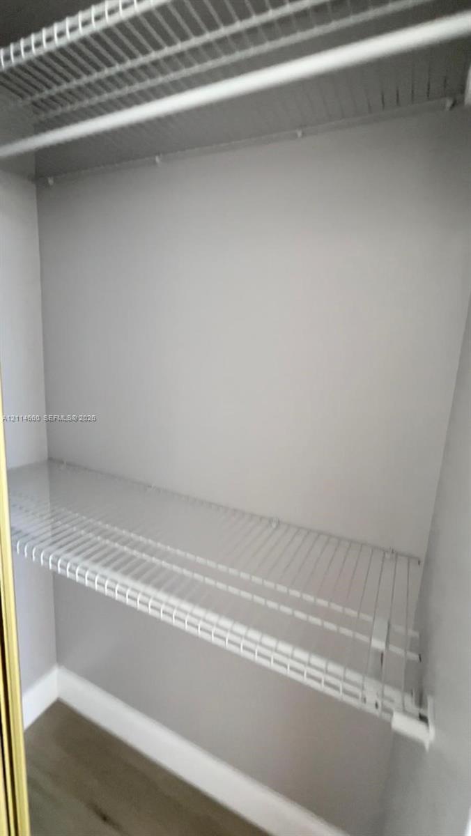 Closet featuring white wire shelving and wood-finish flooring