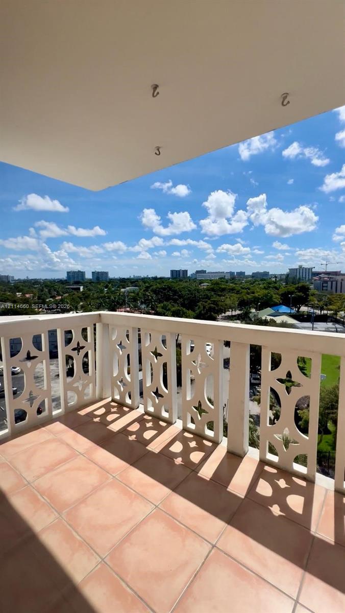Covered balcony featuring geometric patterned railings and tiled flooring
