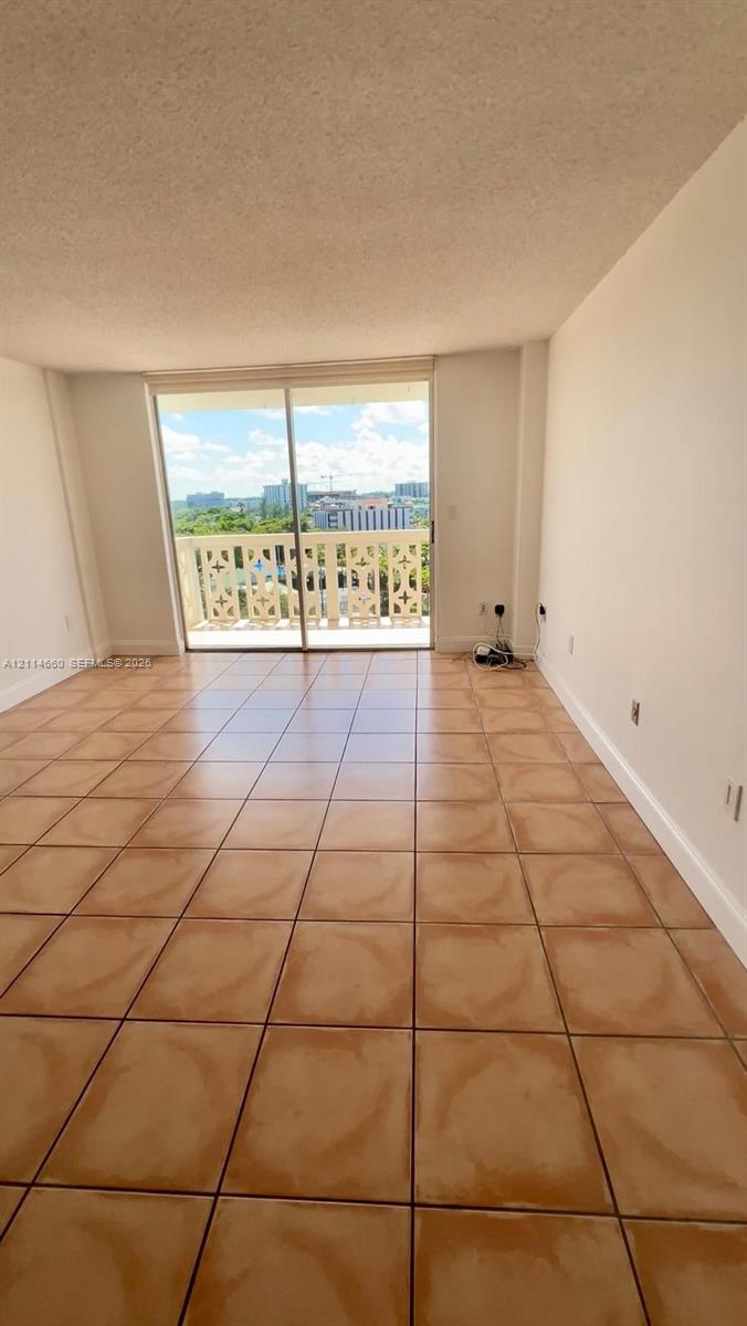 Ceramic tile flooring, sliding glass balcony door, and exterior balcony with decorative railing